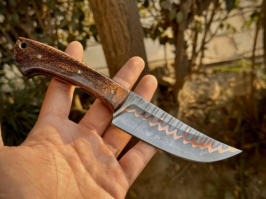 Handcrafted CuMai collector’s knife in outdoor setting, ideal for camping or bushcraft

